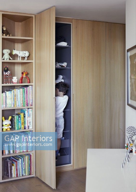 Child in cupboard of modern childrens room