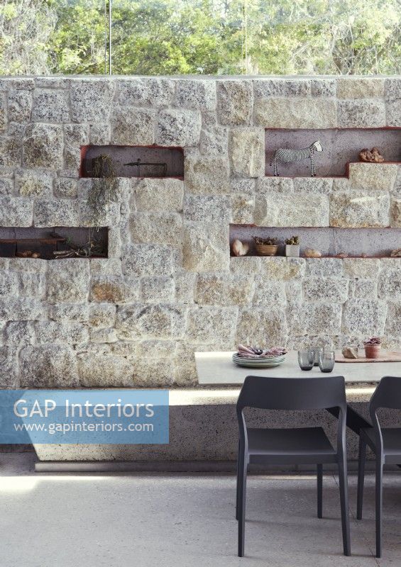 Display of ornament set in alcoves of stone wall of dining room
