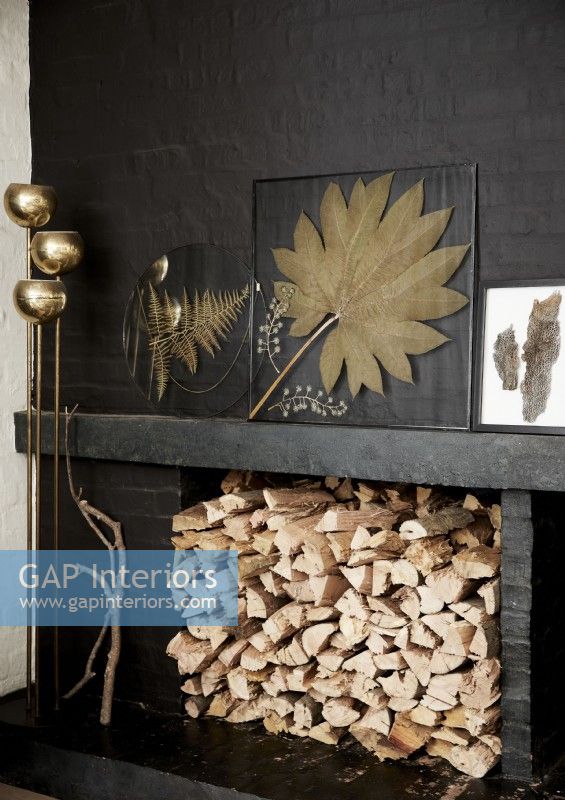 Framed dried leaves on black mantelpiece