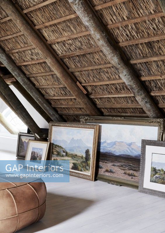 Display of classic landscape paintings on floor of country living space