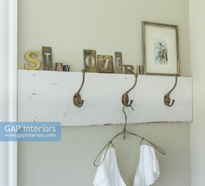 Hooks, like these vintage schoolhouse-style coat hooks, provide extra storage in a small bedroom.