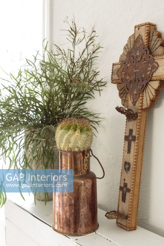 Objects with patina and meaning pair well with frilly greenery along the mantel. 