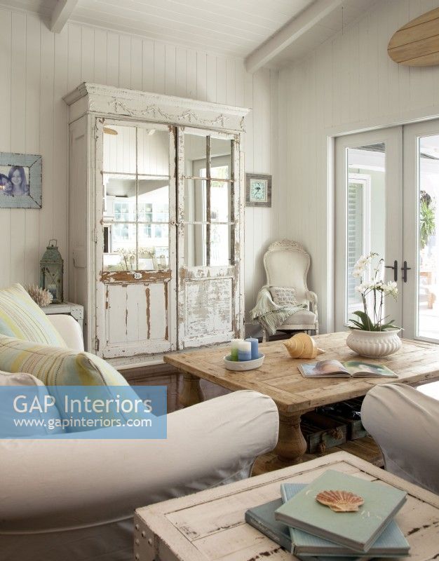 Outfitted with comfortable sofas and chairs, the family room doubles as a reading room. A vintage armoire conceals the T.V in style. The French doors open onto a loggia, the pool and the view of the bay.