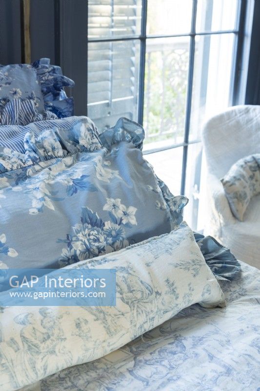 Renee keeps the bedroom French blue and white theme fluid with pillows sporting variations on the hues and floral and pastoral patterns.