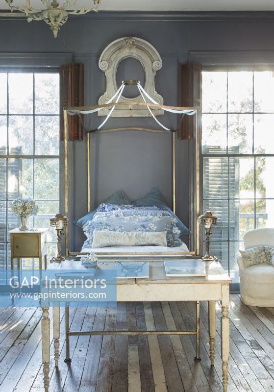A one-of-a-kind iron tester bed was cus-tom welded for the bedroom by master craftsman Larry Rousell. Floor-to-ceiling windows meet original wood floors, patched together from what Renee could salvage from the fire. â€œI do love the color contrast on the floor!â€ she says