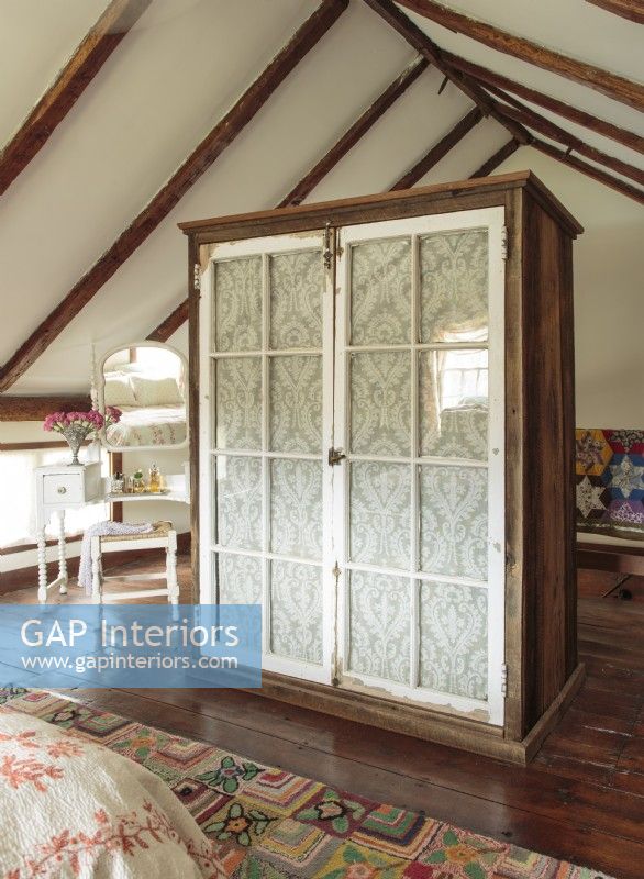 The wardrobe was constructed with locally sourced barn boards and Victorian pantry windows lined with inexpensive cotton lace. 
