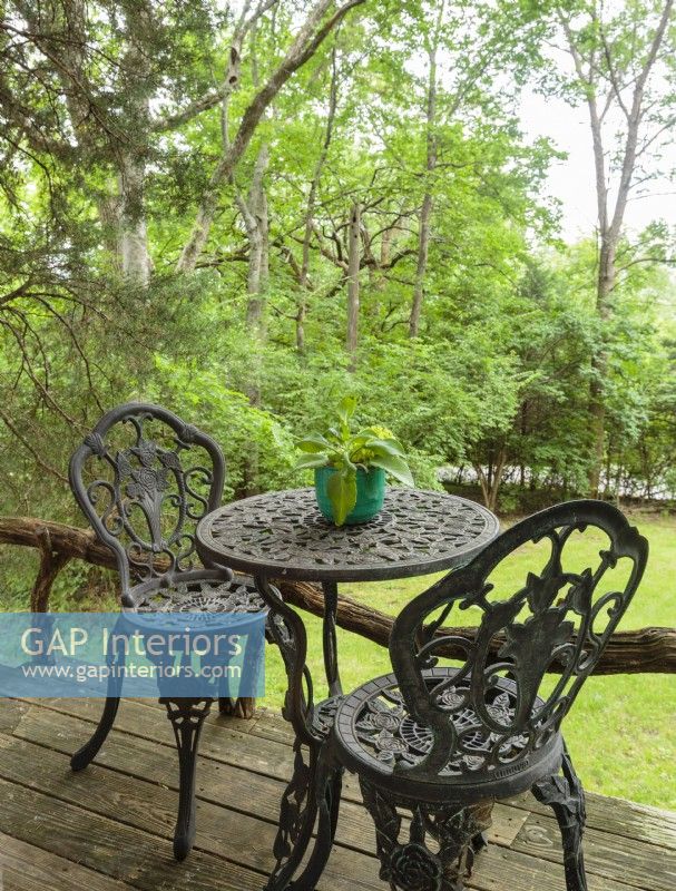 The couple furnished the place with rustic and secondhand finds from local stores, including this tiny bistro set that is just the right size for the narrow deck.
