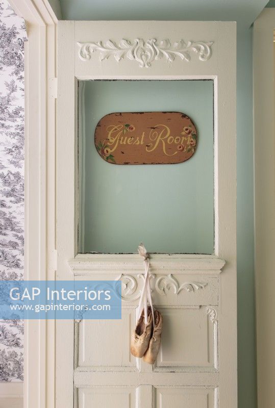 With its handprinted sign and ballet slippers, the door leading from the hallway to the guest room sets the tone for the inviting space. 