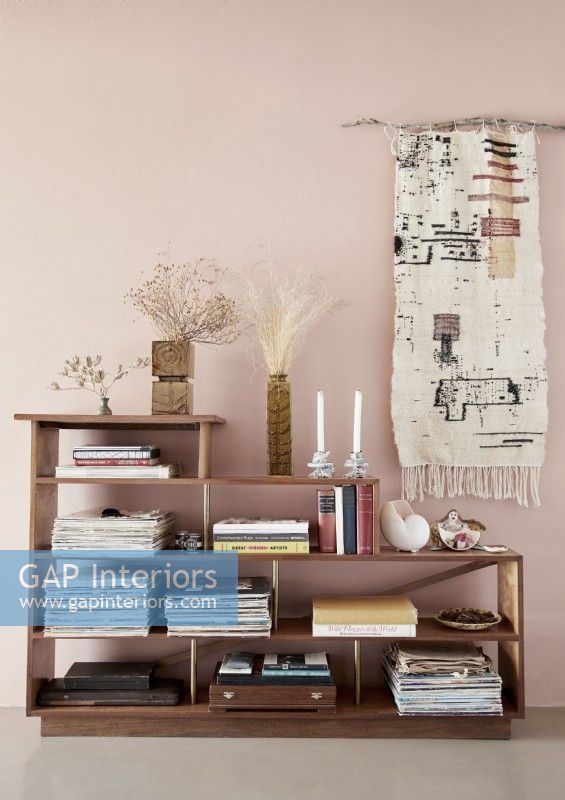 Fabric wall hanging behind wooden shelving unit