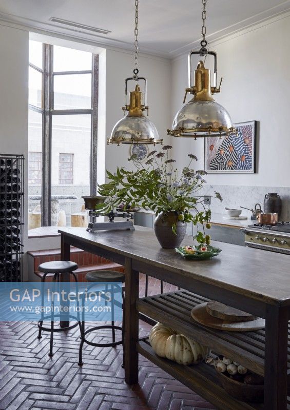 Large salvaged lamps hanging over wooden kitchen island