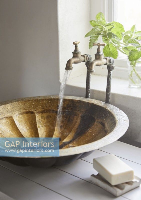 Small bowl sink and brass taps running water