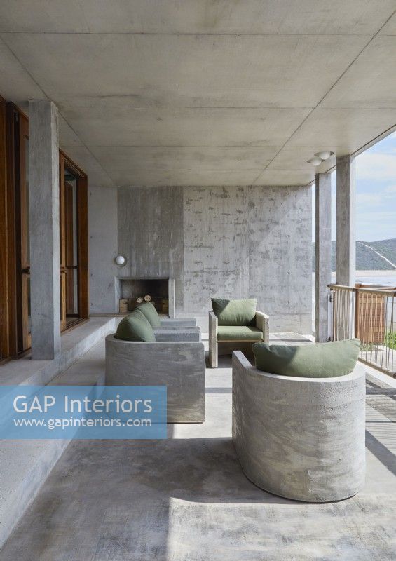 Built-in concrete chairs on balcony with fireplace and sea views