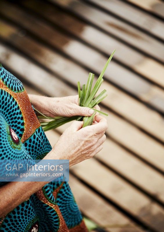 Detail of woman tying a bundle of leaves together