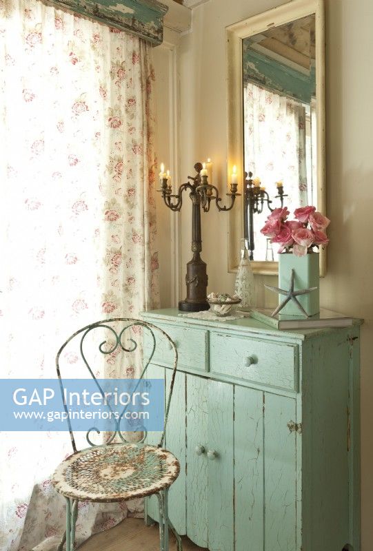At all mirror adds light to the bedroom corner. A weathered garden chair color pairs well with the dresser's.