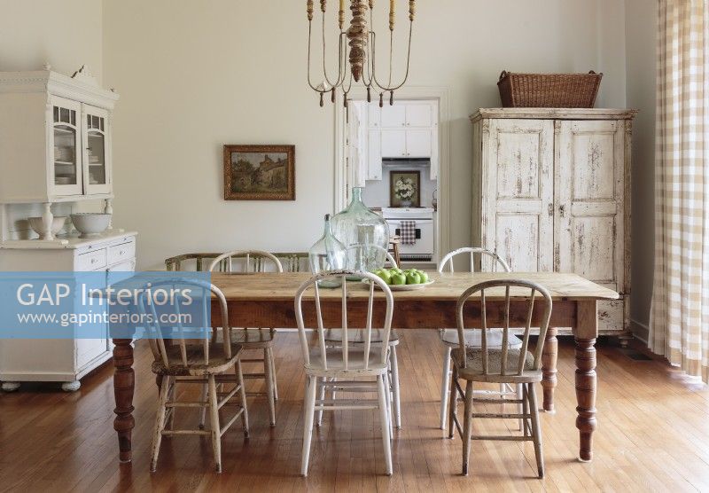 Christi combines her fondness for flea market painting, curious antique light fixtures and timeworn paint finishes in the sparely furnished dining room. 