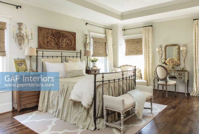 The master bedroom centers on a grey and cream color scheme with a reproduction Parisian architectural find.