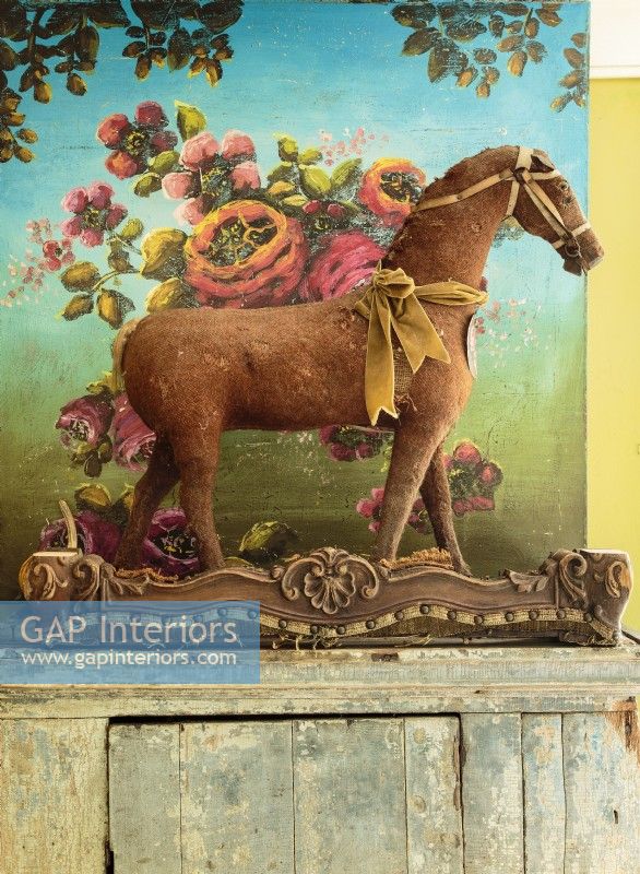 Jennife's painting, 'Lust For Life', forms a colorful backdrop for a vintage horse set atop a distressed armoire.