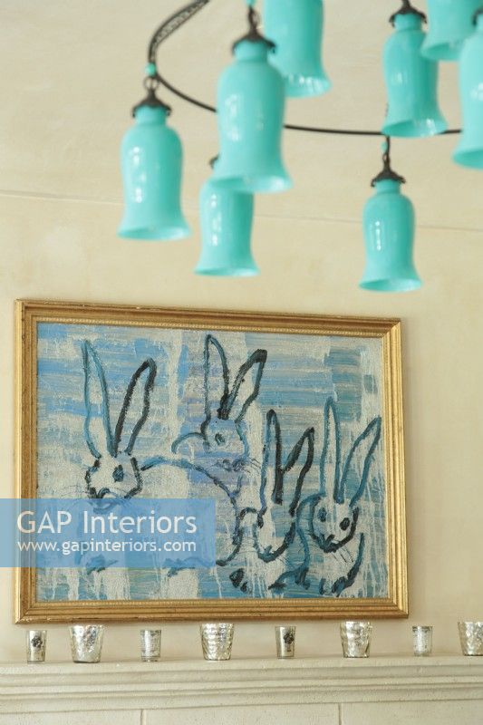 A teal blue glass chandelier adds an unexpected dash of color up high. A bunny painting inspired the roomâ€™s palette.