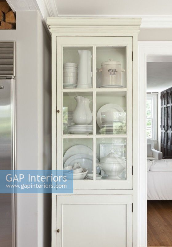 A tall, slender cupboard offers an elegant storage solutions for delicate serving wares.