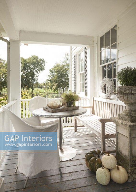 Overlooking rolling hills and pastures, the farmhouse front porch is a favorite place for the family to gather.