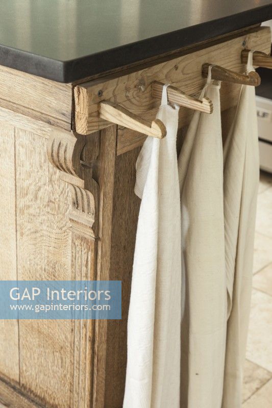 Wooden pegs attached to a board of similar finish make a classy and efficient towel rack. 