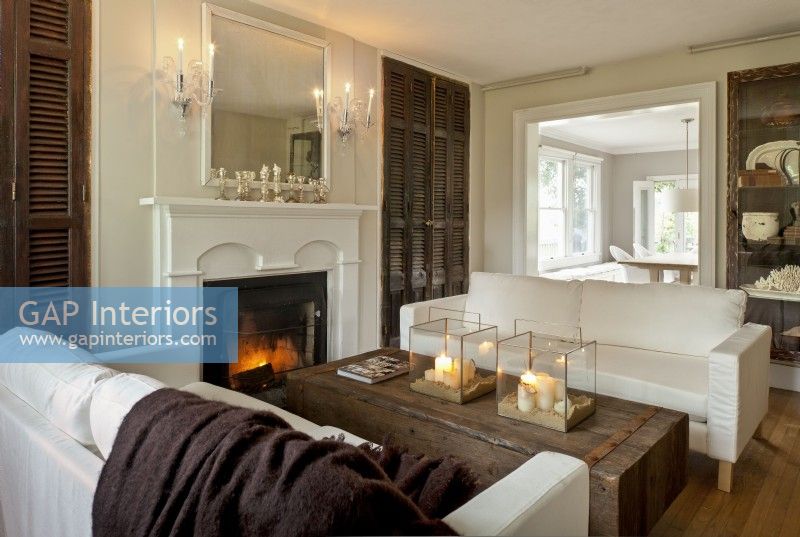 Stained to deep brown, the stately, ancient French shutters flanking the fireplace were repurposed as doors to conceal new closets. 