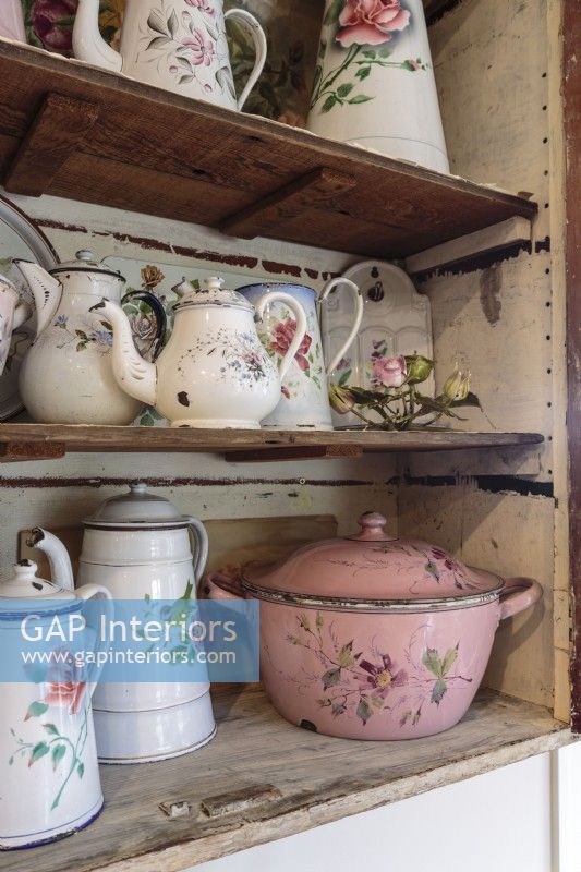 French enamel pitchers, a covered soup tureen, and pots and bowls make for a colorful cluster too pretty to keep behind solid doors.