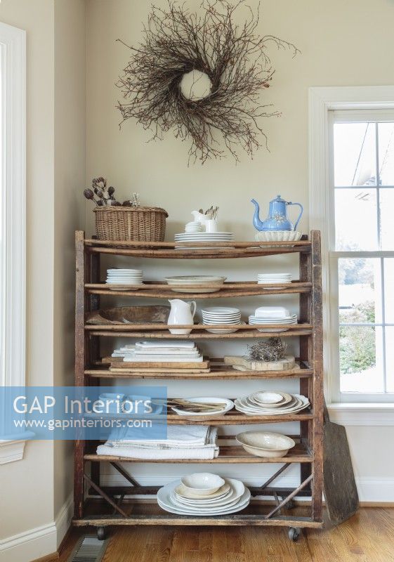  An antique shoe rack stores linens and ironstone within reach.