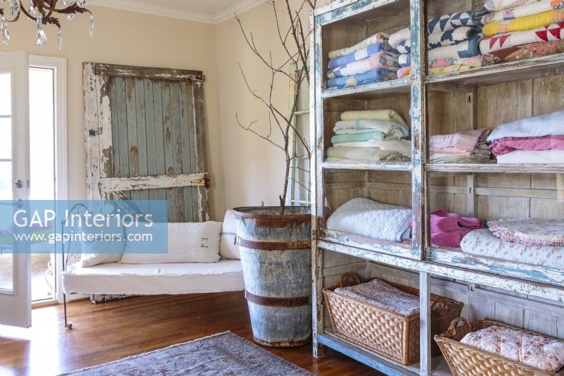 The decor throughout the Zurian home is  a balanced blend of rugged and pretty. Chipped finishes and coarse textures keep sweeter items such as pastel quilts in check.