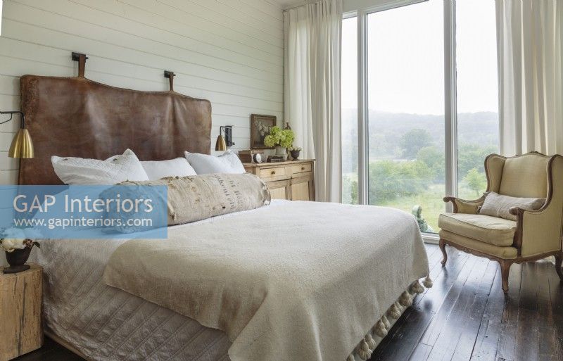 An antique leather mat turned headboard and a tattered bolster stitched from a German feed sack reminds guest that the loft is part of a working farm.
