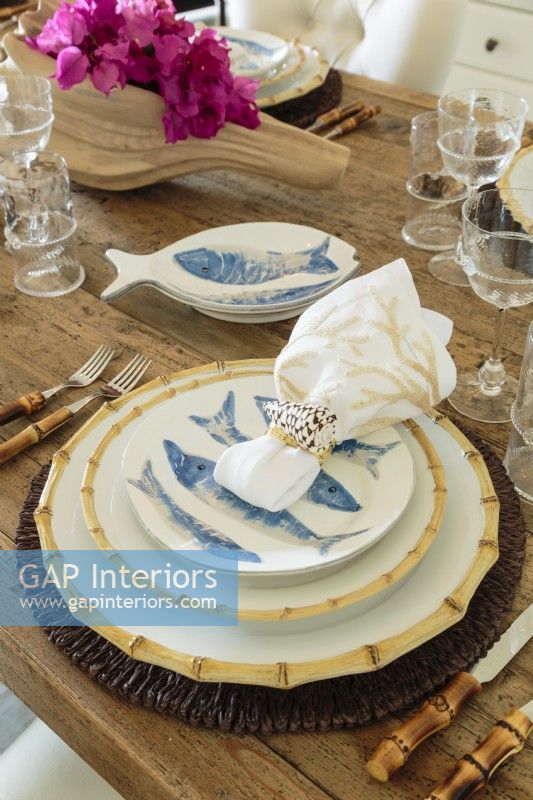 The inviting table setting included rattan chargers,Classic Bamboo china by Juliska, ceramic fish bowls and shell napkin rings. 