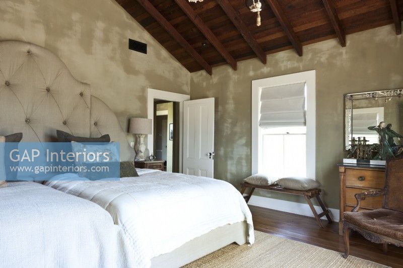 The aged patina of the master bedroom's walls was created by a treatment that involves mixing paint with water and spraying it on wet plaster.