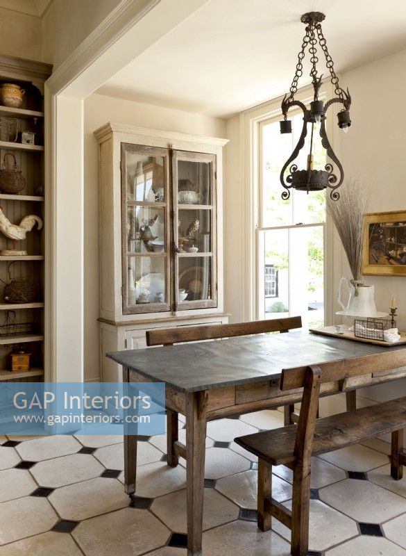 Streamlined and durable wood benches flank a rustic table with a zinc top that can handle spills with ease. 