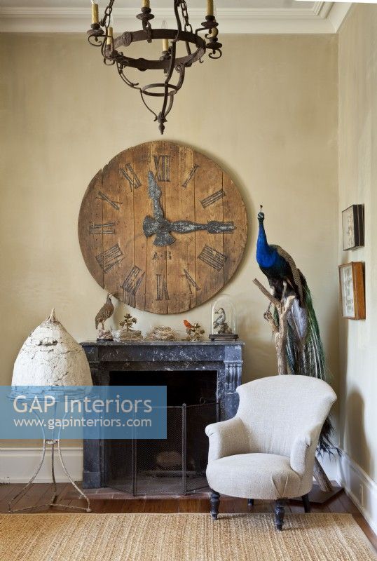 A clock keeps watch over a European white mud beeskep and a colorful taxidermy 