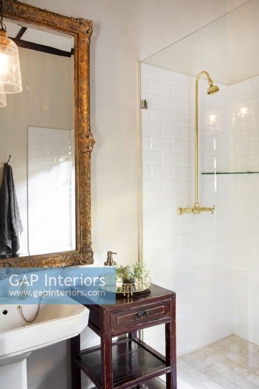 Guest bathroom with large ornate mirror and Chinese side table