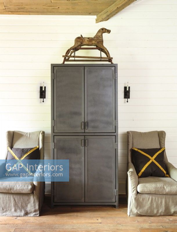 Symmetrical accents and a salvaged armoire keep the room tidy.