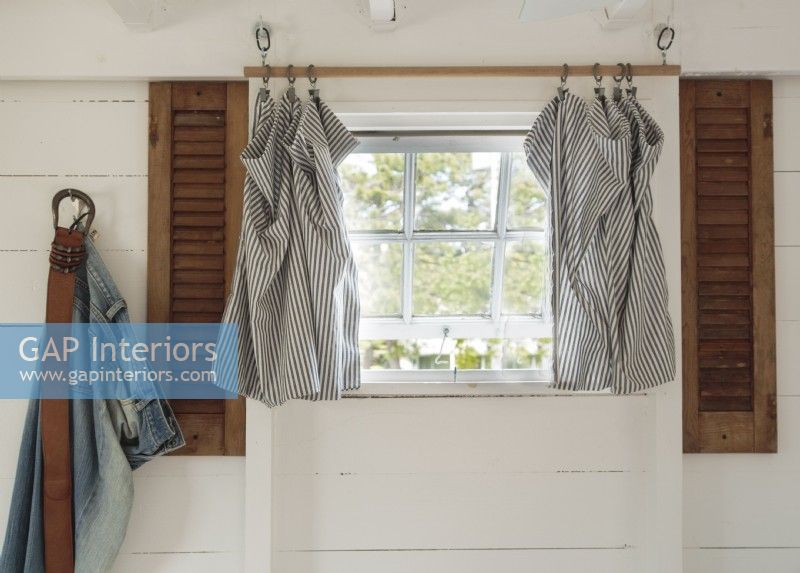 Shutters and handmade curtains contribute to the beachy look.