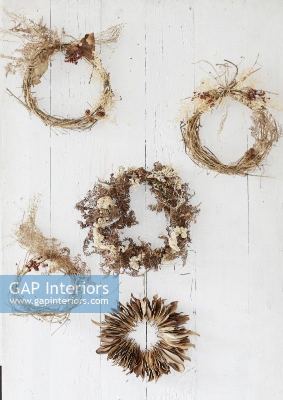 Detail of rustic dried wreaths on white wall