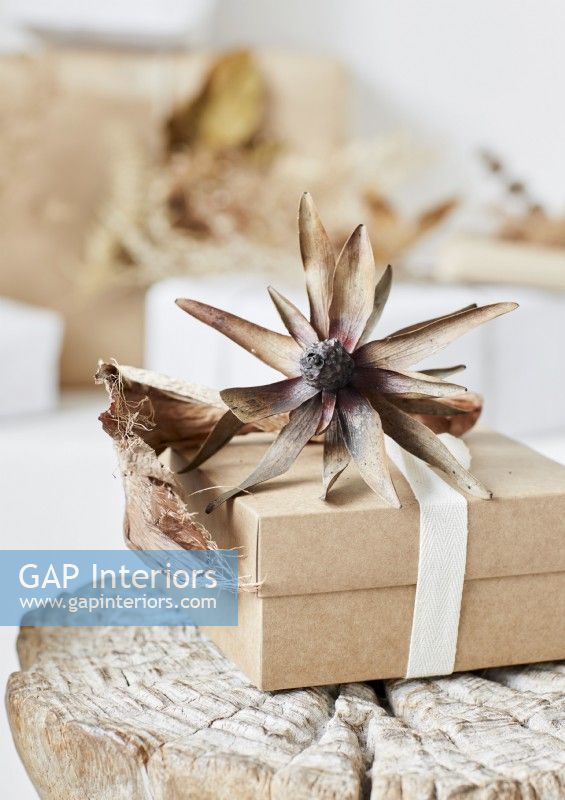 Detail of rustic Christmas gift decorated with large dried flower