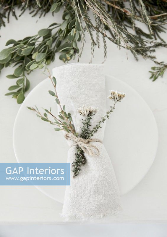 Detail of rustic place setting with napkin and natural decorations