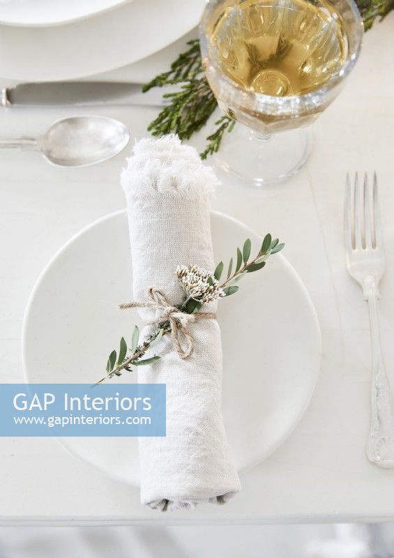 Detail of white place setting with natural decorations
