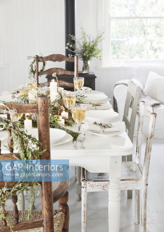 Rustic white dining table laid for Christmas dinner