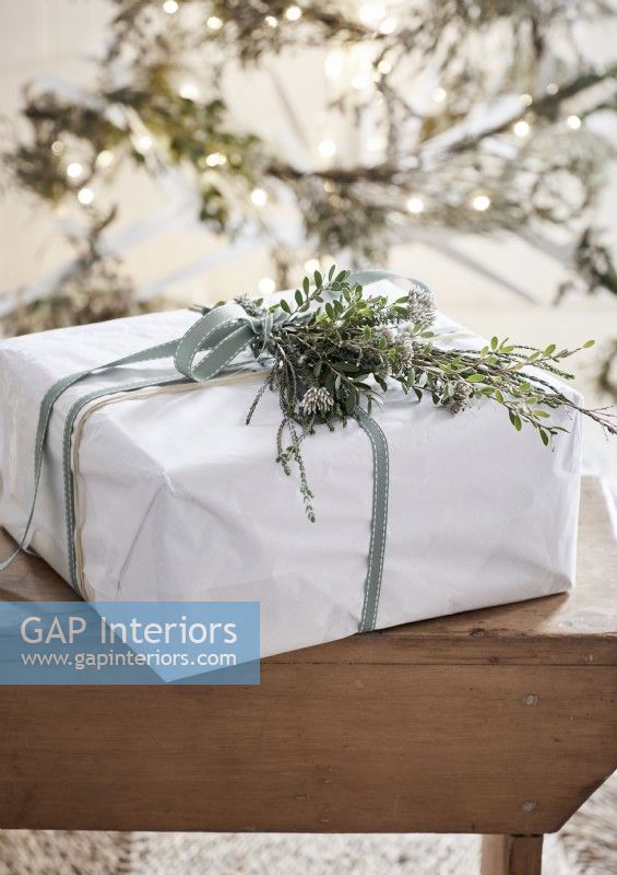 Detail of white Christmas present with natural decoration and ribbon 