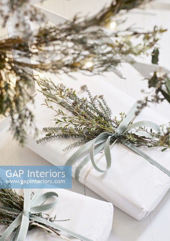 Detail of white Christmas presents with natural decorations