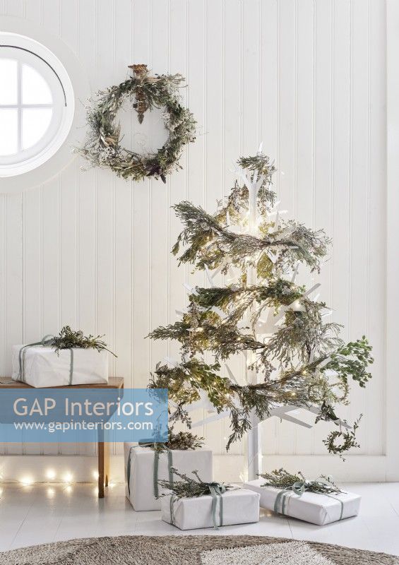 White wooden Christmas tree decorated with natural garlands