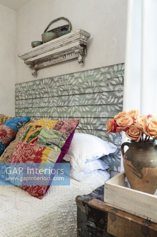 Stenciled salvage planks are fashioned into an exotic headboard.