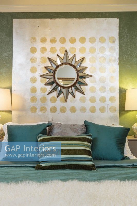 A stardust mirror over a pattern of gold-foil dots make a striking focal point