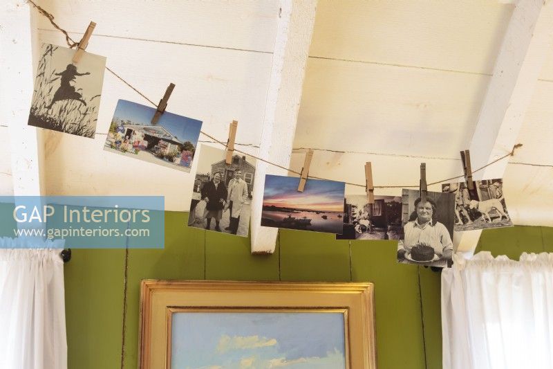 Old photographs and postcards casually hung with clothespins from a line epitomize the beach house lifestyle. 