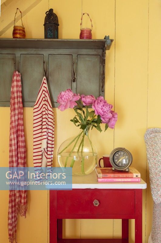 Red accents in the enamel-top nightstand and striped floor amp up the visual heat. 