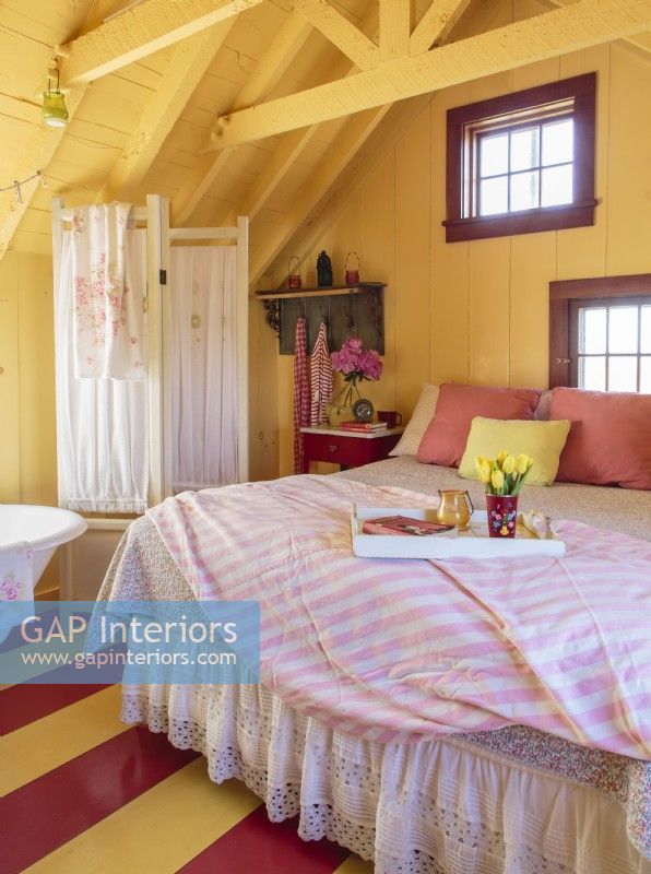 Yellow walls and ceiling wrap the bed and bath suite in sunshine. 